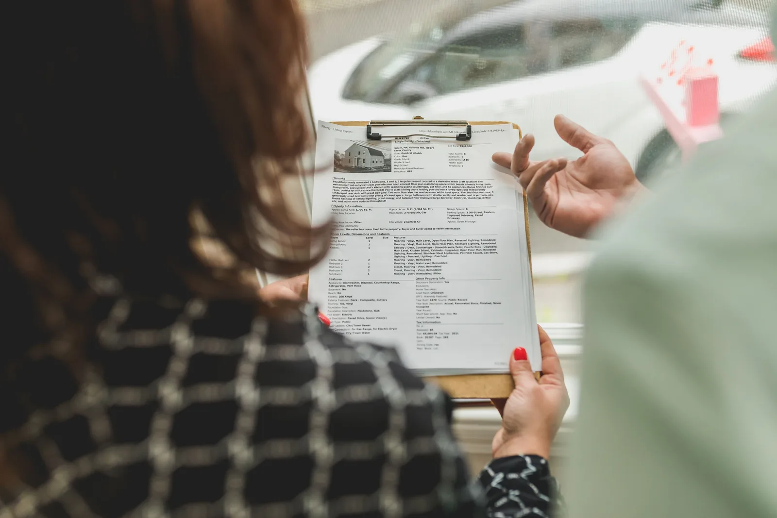 Real estate agent reviewing property documents with a client. Acquisitions and exits: reading deal mechanics