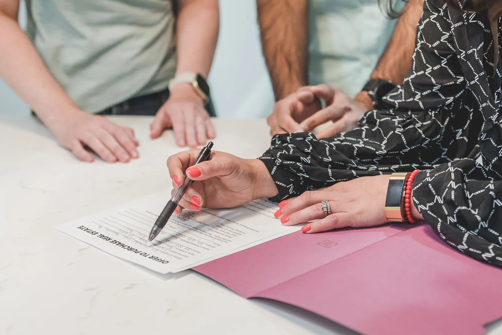 Close-up of hands signing a real estate document at a meeting table with three people. Why 'Best Acquisitions and Exits 2027' Isn't a Ranking